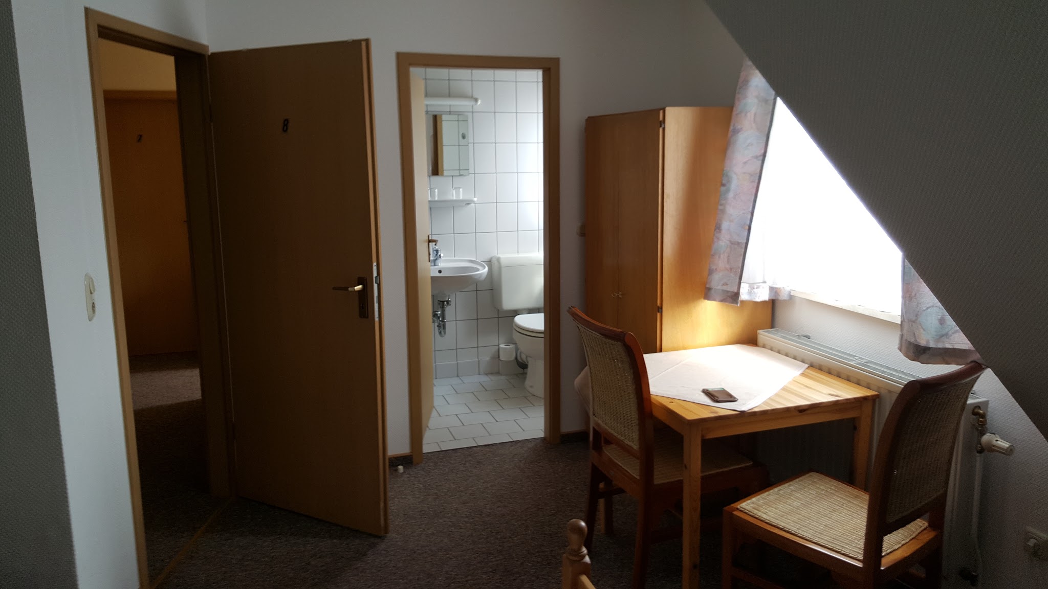 Fremdenzimmer 8 mit eigenem Bad, Schreibtisch und Stühlen im Gasthof Zum Elmblick